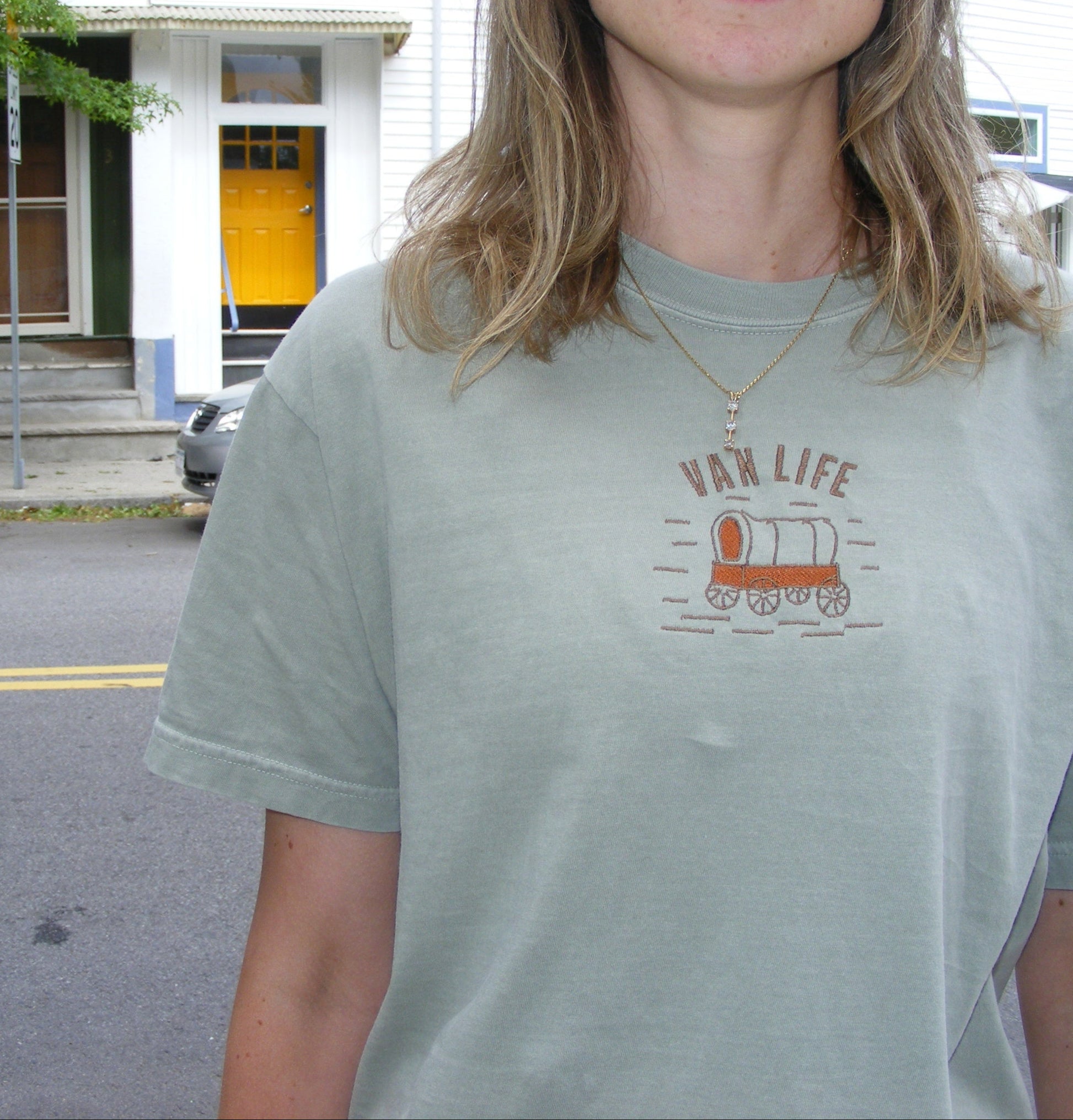 Model wearing Van Life shirt by Broider outdoors. Embroidered cotton tee for vanlifers and road trip lovers, made in Boston.